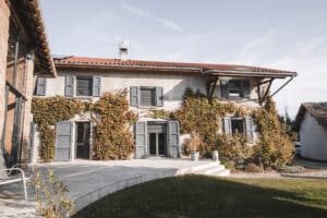 Bâtisse rénovée avec volets roulants solaires LAKAL et volets battants peints en gris anthracite