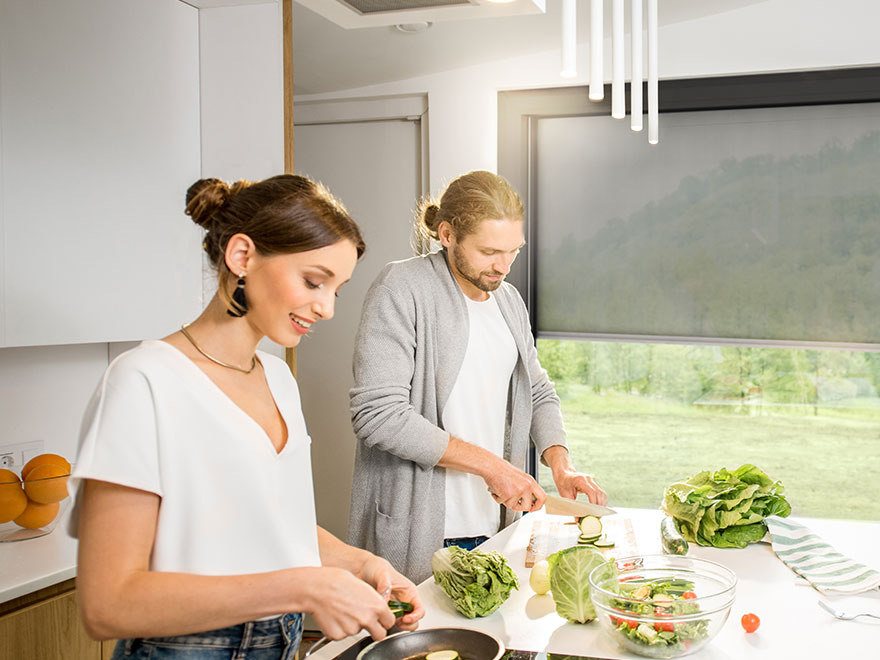 Junges Paar beim Kochen im Hintergrund ist eine Fenster mit Screen zu sehen
