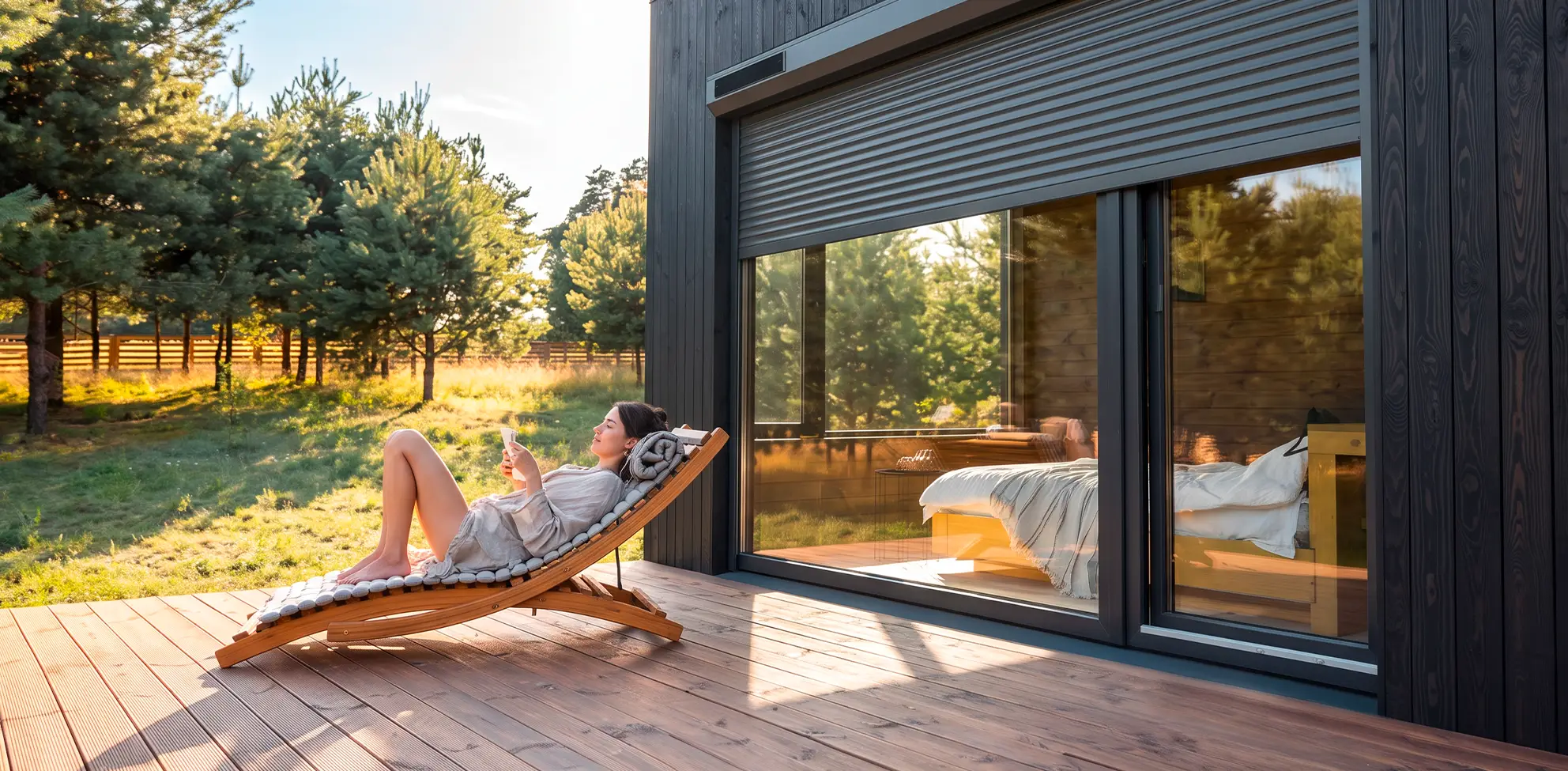 Frau genießt die Sonne auf der Terrasse. Im Hintergrund ist eine Fenster mit Solar-Rollladen